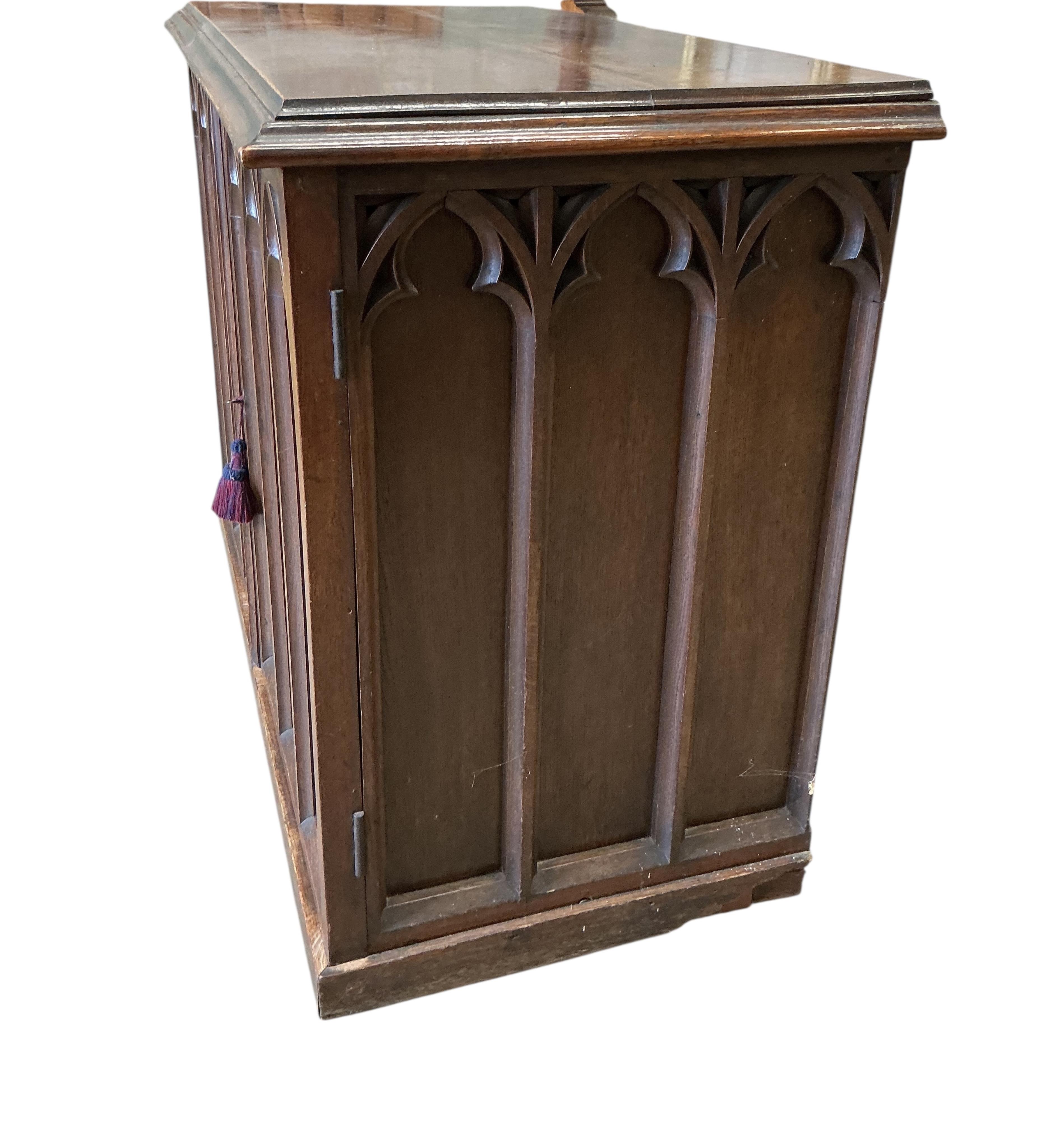 A late Victorian Gothic style oak two door side cabinet, width 122cm, depth 62cm, height 94cm